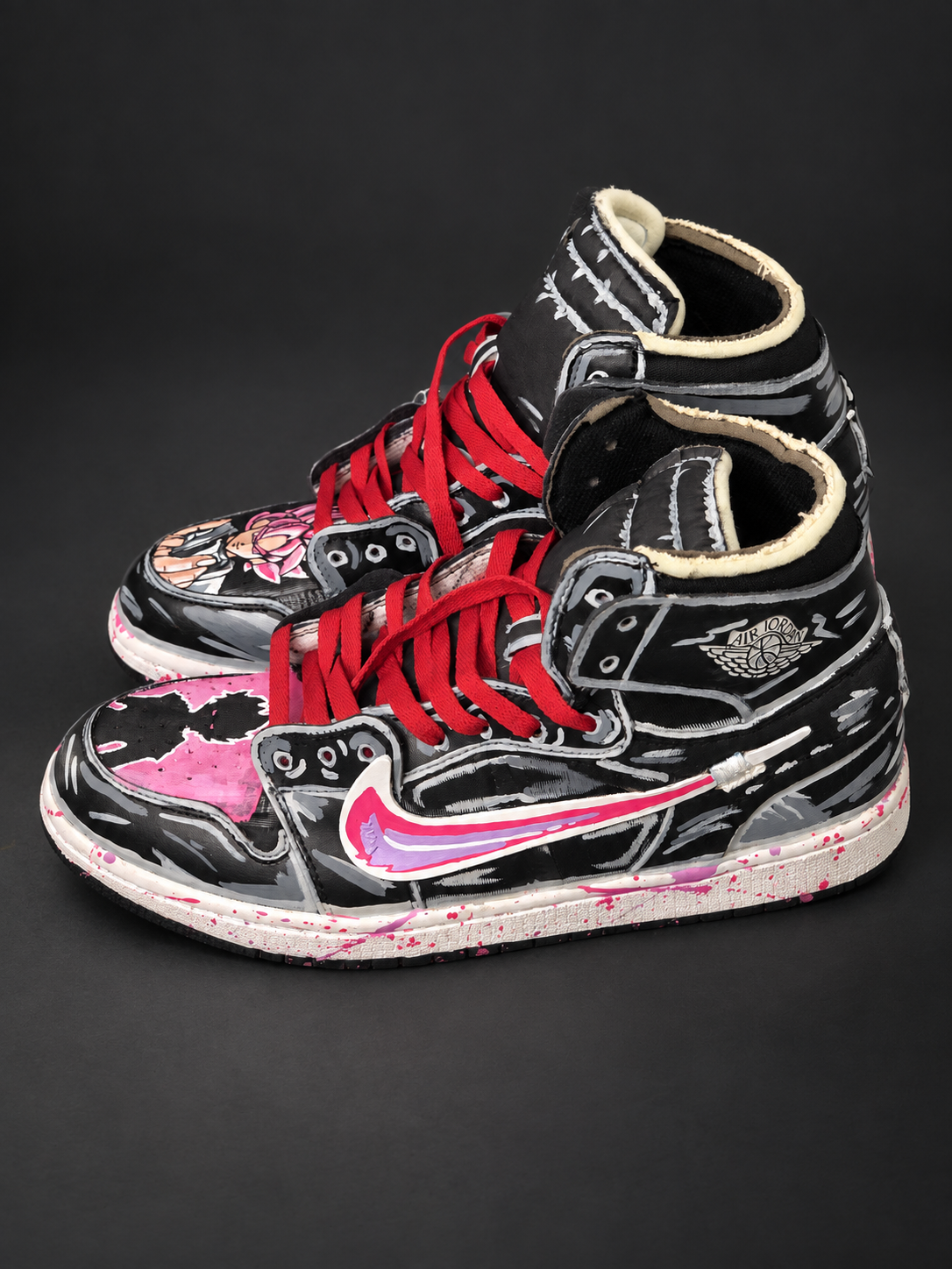 Black and gray high-tops with pink artwork and red laces. View 1 of 3.