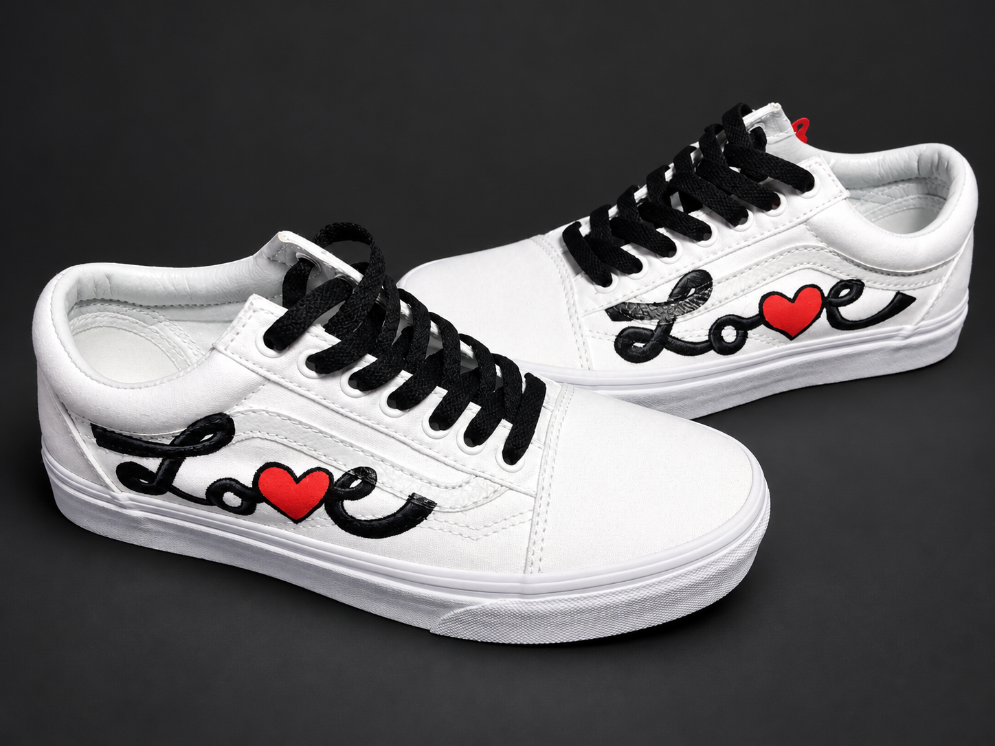 White low-tops with black lettering and red heart details. View 1 of 3.